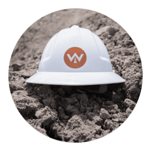 Hardhat with Whitney Logistics logo in dirt