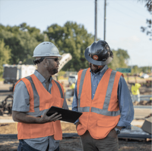 Two Whitney Logistics employees discuss various solutions at a job site.
