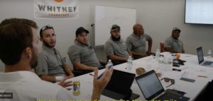 A team of Whitney Logistics employees gather for a meeting on an upcoming project.